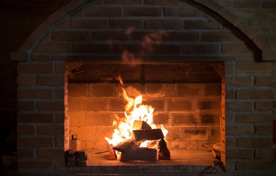 A cozy fireplace burning logs with a bright flame.
